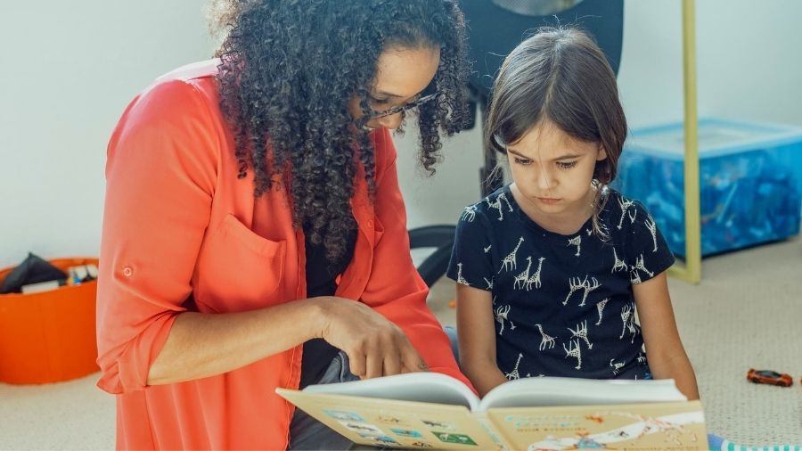 Woman reading a book with a girl