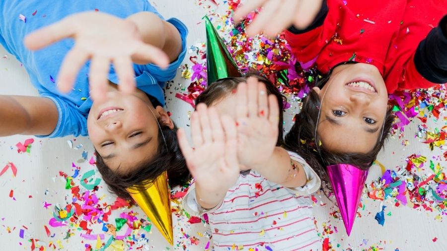 Kids lying on the ground playing with hands up