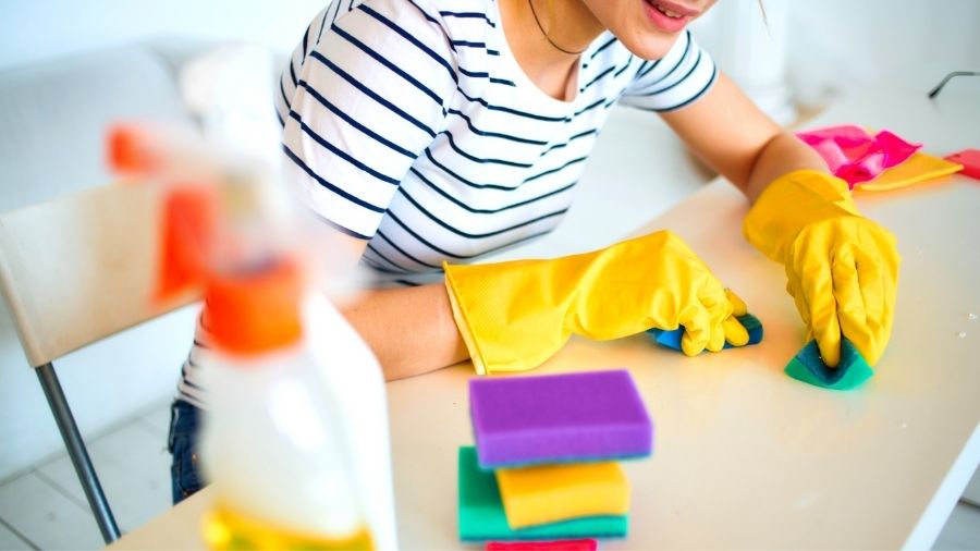 Women cleaning a table with sponge