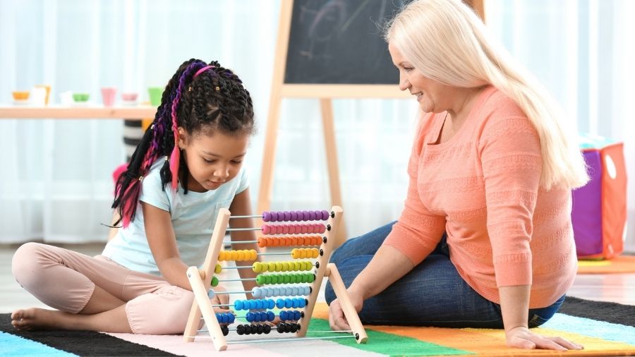 Blond woman playing with young girl on the floor