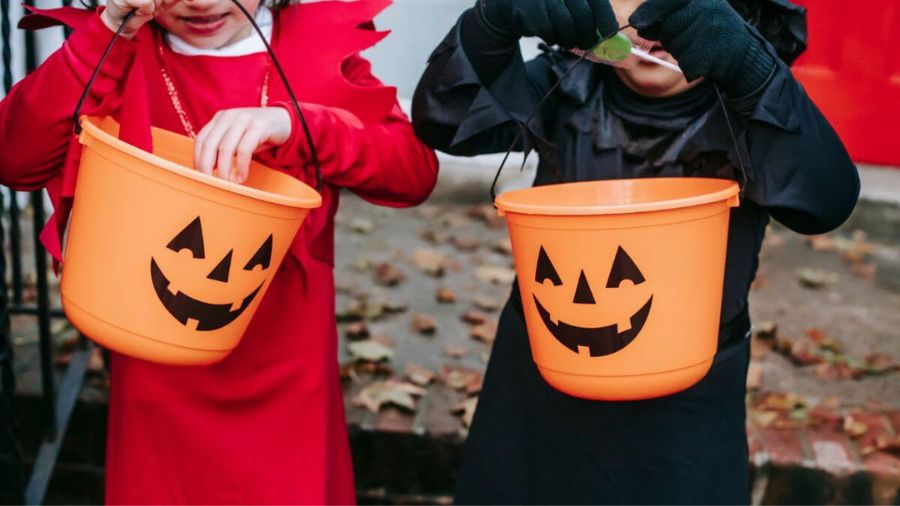 Kids with halloween trick or trat buckets